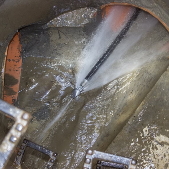 High-pressure water jet cleaning drain pipe.